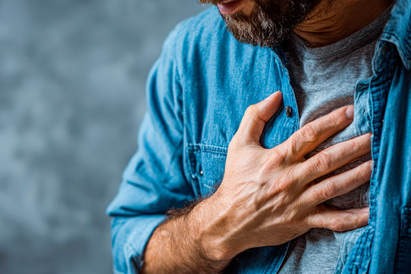 A man holds his chest from chronic pain