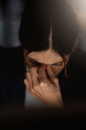 A girl holds her face at work from emotional burnout